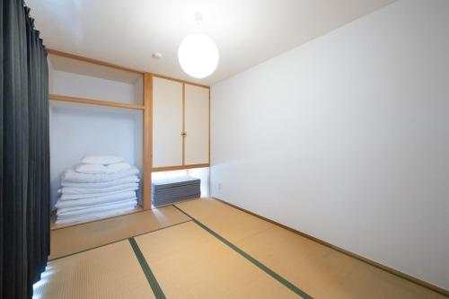 an empty room with a window and a pile of towels at お宿 春Haru in Muromoto