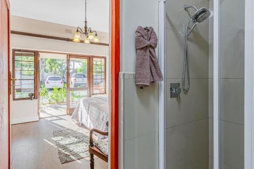 a bathroom with a shower and a bedroom at Caledon 23 Guest House in George