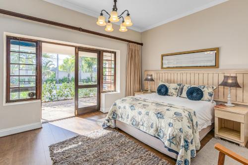a bedroom with a bed and a sliding glass door at Caledon 23 Guest House in George