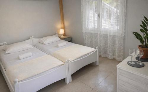 a white bed in a room with a window at Dom Suites in Agioi Apostoli