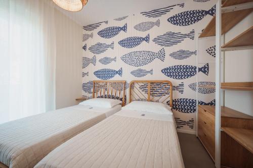 a bedroom with two beds and a fish wallpaper at Casa Costa Sud in Bari