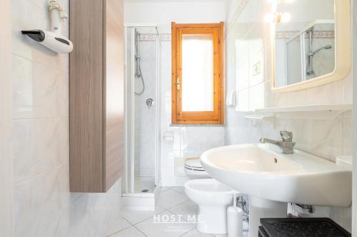a white bathroom with a sink and a toilet at Terrazza 12 - Free Wifi in Costa Rei
