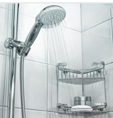 a shower with a shower head in a bathroom at Gardenhouse with private jacuzzi & private sauna in Teteringen