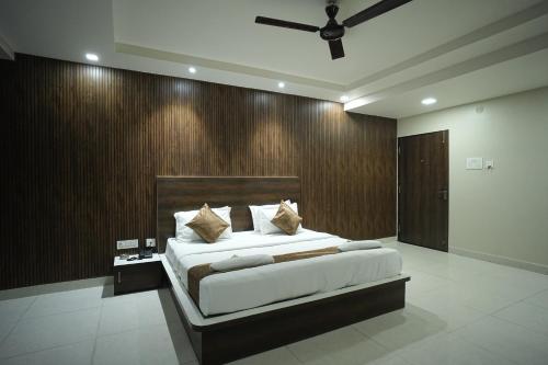 a bedroom with a large bed with a wooden wall at Hotel Jay Palace in Kota