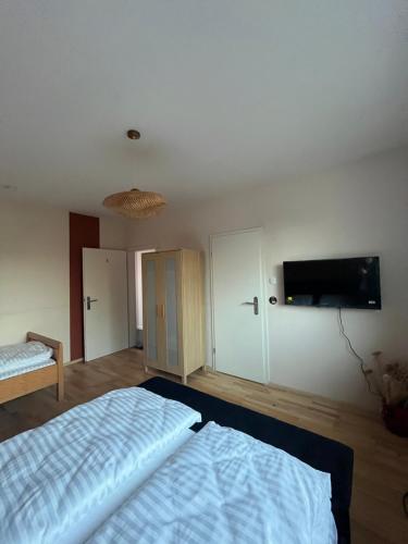 a bedroom with a bed and a flat screen tv at Ferienwohnung Fatlume No 3 in Bad Honnef am Rhein