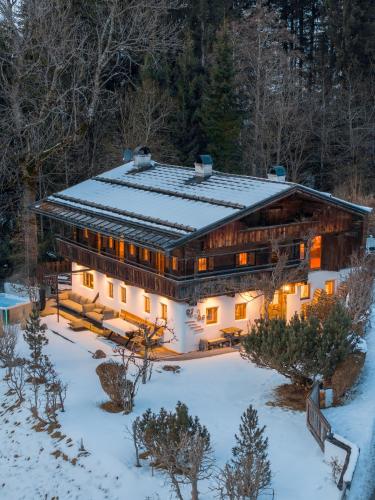 a house in the snow with lights on at Hunters Lodge Chalet Superior in Alpbach
