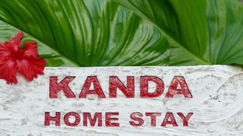 a sign that says karma home stay next to a plant at Kanda Homestay in Sidemen