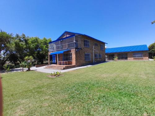 a brick building with a large yard in front of it at Vaaldamhuis in Oranjeville