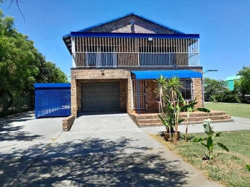 a house with a garage with a blue door at Vaaldamhuis in Oranjeville