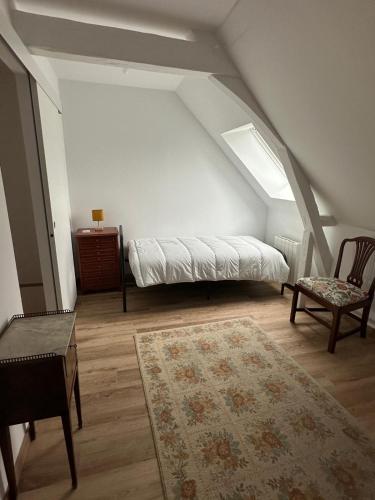 Le Cottage في Ternay: غرفة بها سرير وكرسي في العلية