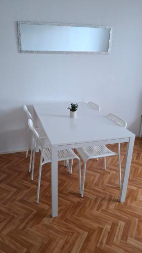 a white table and chairs with a potted plant on it at Appartement entier lumineux in Joué-lès-Tours