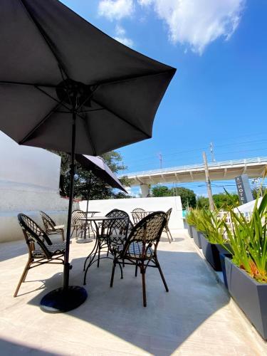 a table and chairs with an umbrella on a patio at Casa Zapopan Hotel in Guadalajara