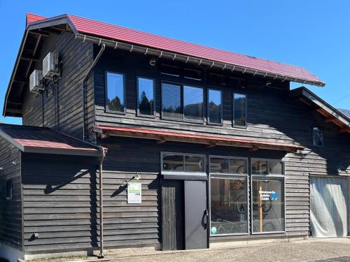 a black building with a red roof at GuestHouse Shirakawa-Go INN in Shirakawa