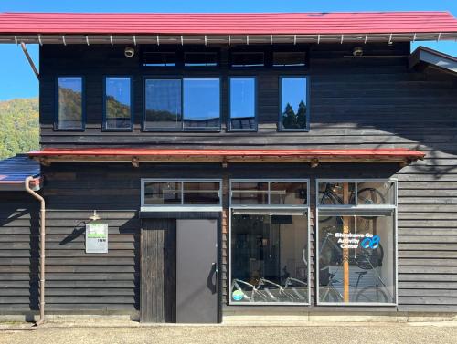 a store front with a red roof and windows at GuestHouse Shirakawa-Go INN in Shirakawa