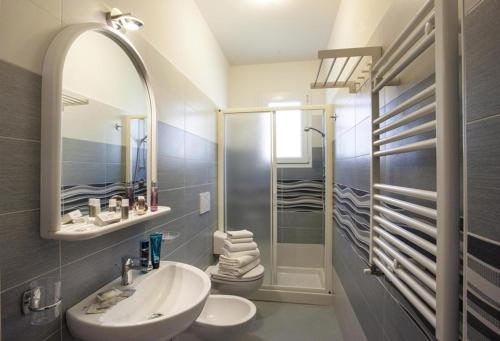a bathroom with a sink and a toilet and a mirror at Villa Marcolini in Cattolica