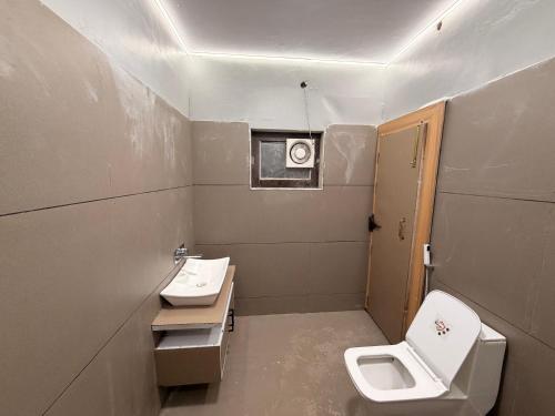 a small bathroom with a toilet and a sink at Govindam Palace in Govardhan