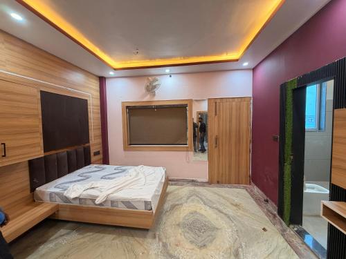 a bedroom with a bed and a flat screen tv at Govindam Palace in Govardhan