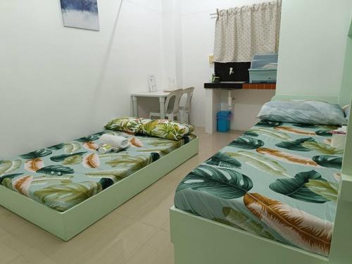 two beds sitting next to each other in a room at JCE Comfort & Simplicity in Tacloban