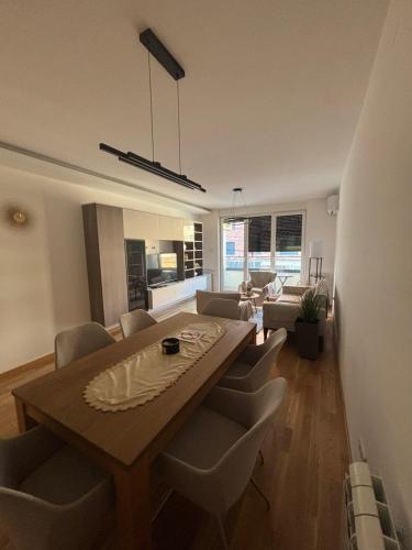 a living room with a wooden table and chairs at Apartman Akademska Četvrt in Čačak