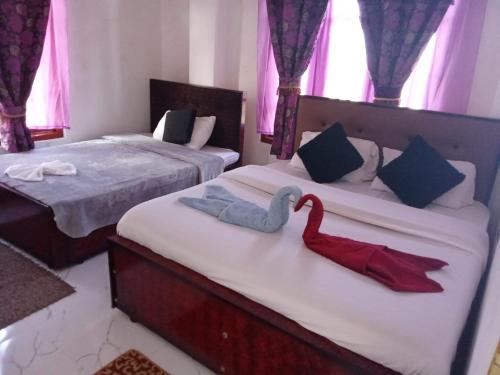 a bedroom with two beds with swans on them at The nest haputale in Haputalegama