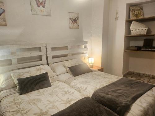 a bed with two pillows on it in a bedroom at Casa de La Abuela Pepi in Aracena