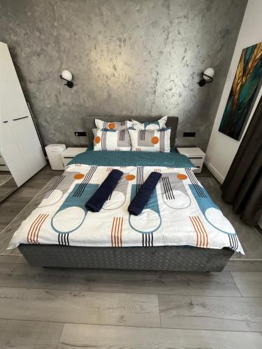 a bedroom with a bed with blue and white sheets and pillows at Ideal House Rent in Petroşani