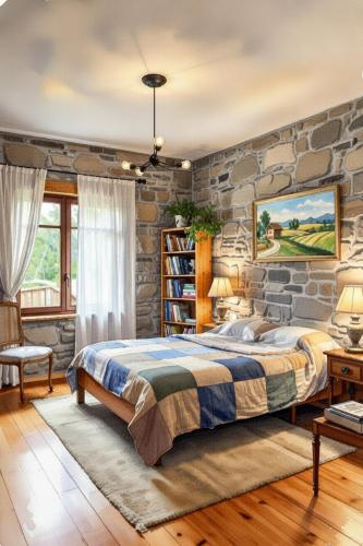 a stone walled bedroom with a bed and a stone wall at PLand Agrotourism in Bharatpur