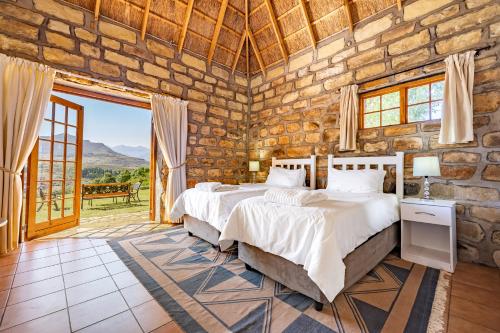 a bedroom with a bed and a stone wall at Ramabanta Trading Post in Setleketseng