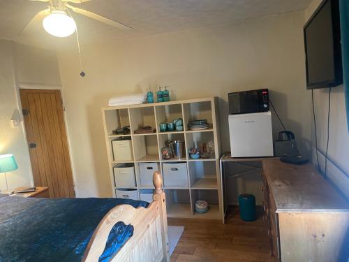 a bedroom with a bed and a white refrigerator at Fenland Gallery in Whittlesey