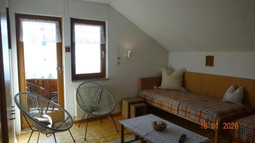 a room with a bed and two chairs and a table at Ferienwohnung Schlemmer in Doren