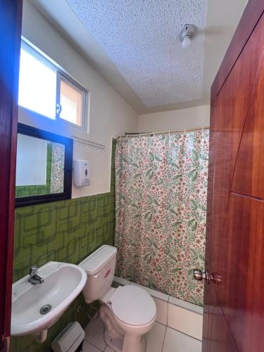 a bathroom with a toilet and a sink and a shower at Hostal Villa Franca in Ibarra