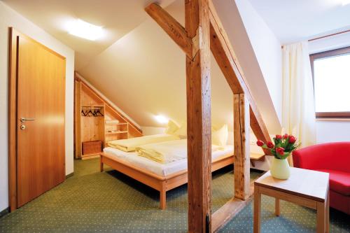 a hotel room with a bed and a red couch at Pension Schindlau in Scharnstein
