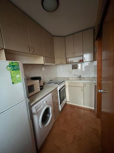 eine Küche mit einem weißen Kühlschrank und einer Mikrowelle in der Unterkunft Apartment Geni in Pomorie