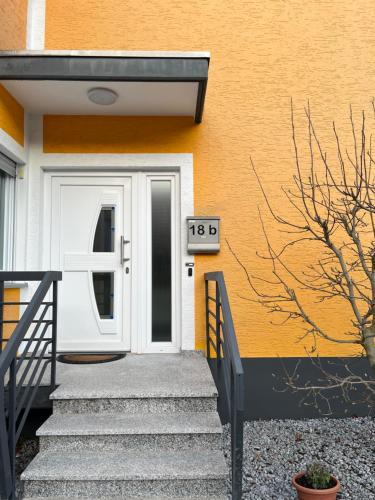 a house with a white door and stairs in front at Ferienwohnung Fatlume No 1 in Bad Honnef am Rhein