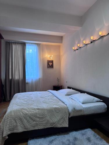 a bedroom with a large bed and a window at Vintage Veranda Apartment in Itʼkhvisi