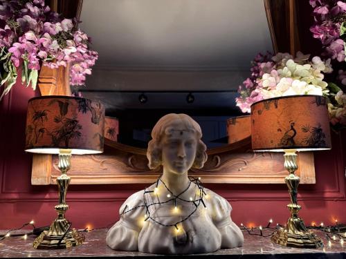 a statue of a woman sitting on a table with two lamps at B&B Alexandre in Herzele