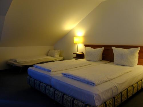 two beds in a hotel room with acknowled at Landhaus Lockwitzgrund in Lockwitz