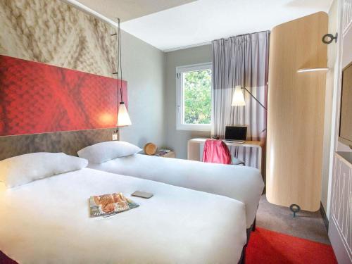 a hotel room with two beds and a window at ibis Brignoles Provence Verte in Brignoles