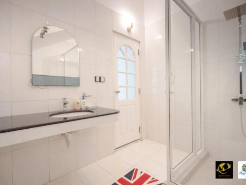 a white bathroom with a sink and a shower at Azure Heaven Villa in Wennappuwa