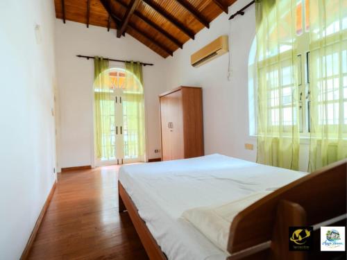 a bedroom with a bed and two large windows at Azure Heaven Villa in Wennappuwa