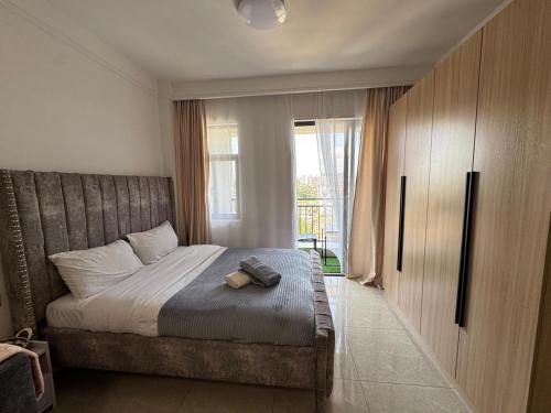 a bedroom with a bed and a large window at The Royal Retreat in Ruaka
