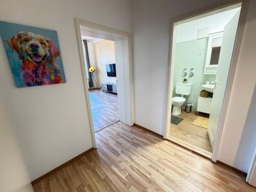 a hallway with a painting of a dog on the wall at Ferienwohnung am Altmarkt, für bis zu 4 Personen, 55qm in Cottbus