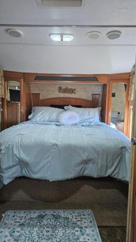 a bed on a boat with a wooden head board at Starry Skies RV in Victoria