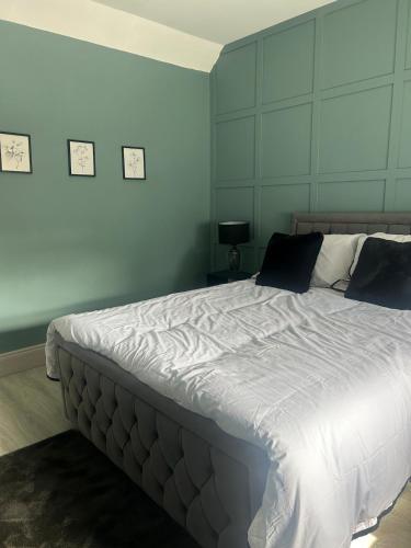 a bedroom with a large bed with blue walls at Clontrain Cottage in Carrickmacross