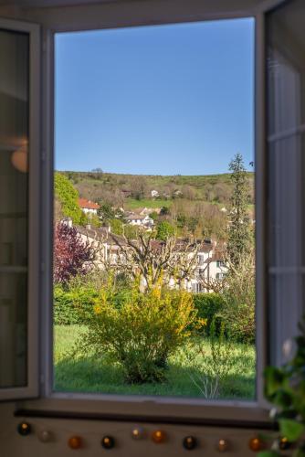 a window with a view of a yard at Le St Géraud, 3 chambres, Prémium avec Fibre, Centre Aurillac in Aurillac