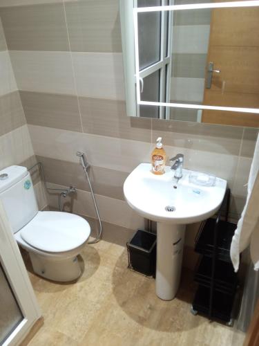 ein Badezimmer mit weißer Toilette und Waschbecken in der Unterkunft Chez Basma in Rabat
