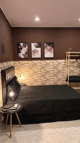 a bedroom with a black bed and a table at Casa do João in Maricá