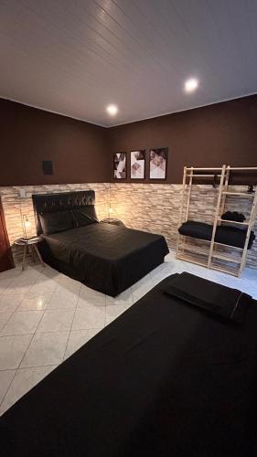a bedroom with two beds and a brick wall at Casa do João in Maricá