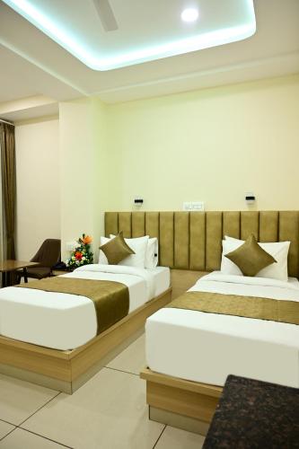 a hotel room with two beds and a table at SR Grand in Tumkūr
