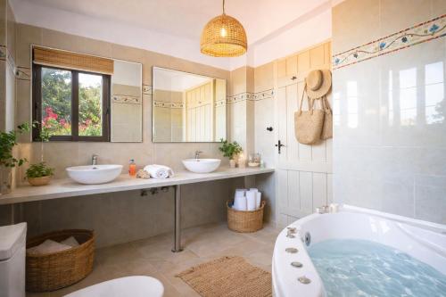 a bathroom with two sinks and a bath tub at Villa Seli in Gerani